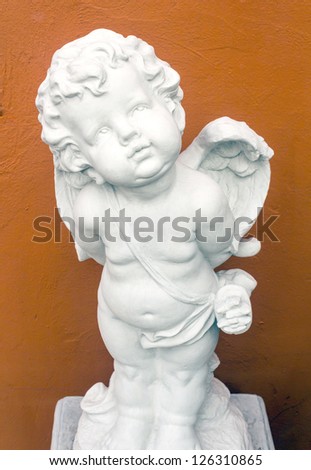 The statue of Cupid in orange background