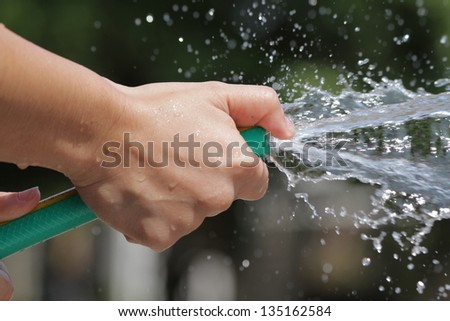 Holding a water rubber hose tube. Watering. hose down.