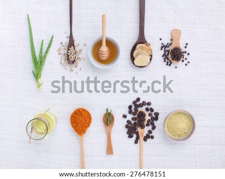 herb variety on rustic white background from top view, oil, coffee, beans, pepper, aloe vera, turmeric, ginger, rosemary