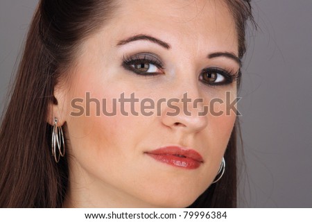 Close-up of a lovely young brunette with a serious facial expression.