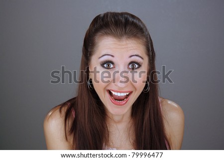 Close-up of a lovely young brunette with an excited or surprised facial expression.