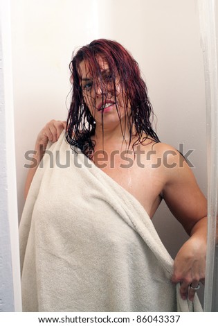 A sexy redhead emerges from the shower covered by a towel.
