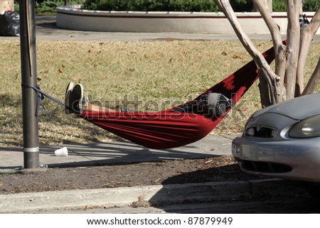 ORLANDO, FL - NOVEMEBER 1:  An unidentified Occupy Orlando protester sleeps in his makeshift hammock in the camp across from the Orlando Chamber of Commerce on November 1, 2011, in Orlando, FL.