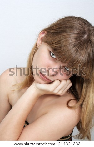 A close-up of a lovely teenage girl with a with a sad facial expression.