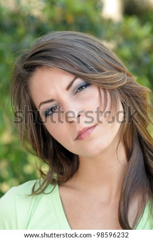 A close-up of a lovely young brunette with a serious facial expression.