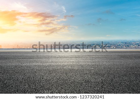 Panoramic city skyline and buildings with empty asphalt road at sunset