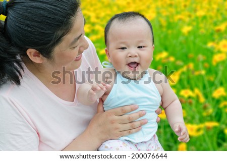 Oriental Mum and her Child playing in Park together