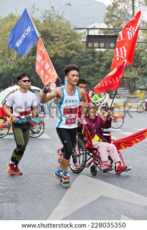 Hangzhou - November 2: international marathon,Chinese athletes Pull wheelchair old man in the running, November 2, 2014 in hangzhou, China. Hangzhou marathon is one of the most important game in China