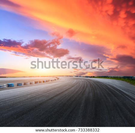 Dark asphalt road circuit and beautiful sky at sunset