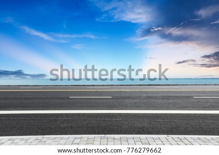 empty asphalt highway and blue sea nature landscape at sunset
