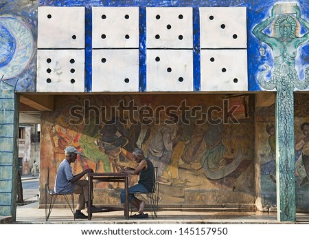SANTIAGO DE CUBA, CUBA - APRIL 12, 2009: Old men playing dominoes on the patio of an old painted house in Santiago de Cuba, Cuba on April 12, 2009. The domino game is the most  practiced in Cuba.
