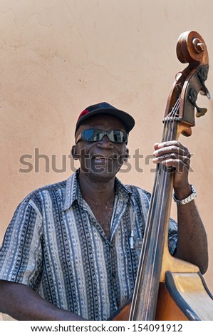 SANTIAGO DE CUBA - APRIL 17, 2009: Old man plays the contrabass on April 17, 2009 in Santiago de Cuba, Cuba. Cuban music is an attraction for the over 2 million tourists who go to Cuba each year.