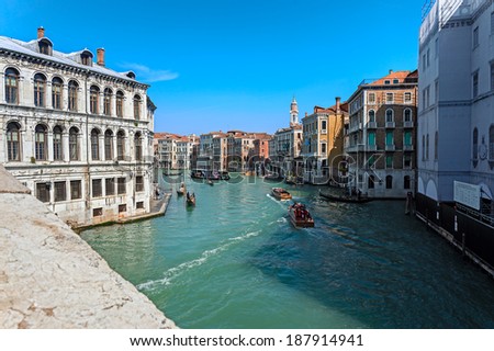 VENICE, ITALY - MARCH 30, 2014: Gondolas and boats with tourists cruising the Grand Canal on March 30, 2014 in Venice, Italy. Gondola is an important means of tourist transportation in Venice.