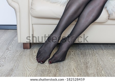 woman puts on her black nylon stockings