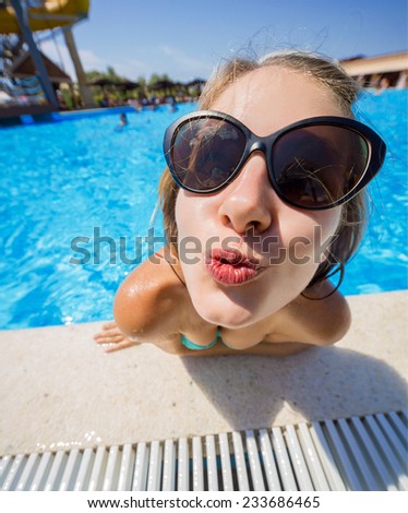girl standing in a pool sends a kiss. filmed at the wide-angle lens