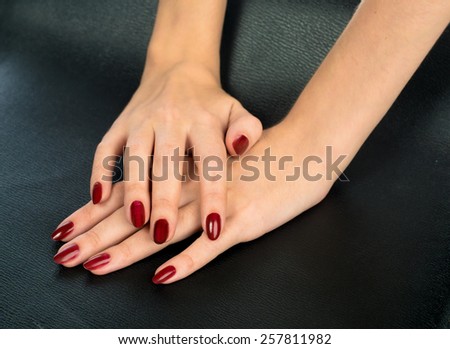 Beautiful female hands. nails in red lacquer
