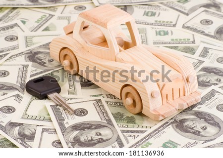 car model with key on a background of 100 dollar bills