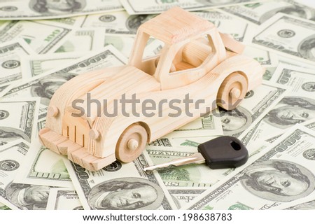 car model with key on a background of 100 dollar bills