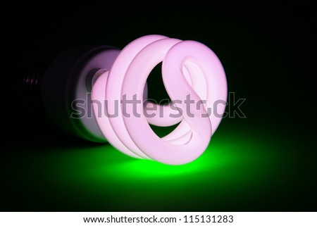 Compact fluorescent (CFL) bulb on green background