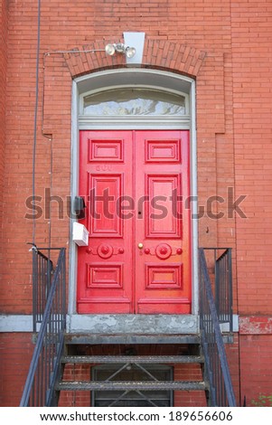Red front door with metal stairs