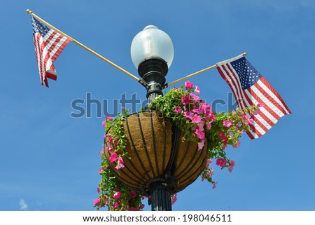Washington D.C. - Street lamp post with United State National flags and flower pot in Georgetown.