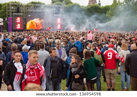 COPENHAGEN, DENMARK - JUNE 9, 2012: seconds after the final whistle, supporters at the temporary fan park in Kongens Have smile, kiss and cheer the victory of underdog Denmark vs. Holland (Euro 2012)