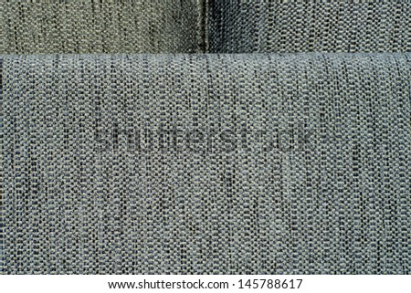 Grey fabric: back of the sofa. Close-up of the grey fabric of a sofa - frame and back of leaning pillows with covering fabric noticeable in spite of abstract look