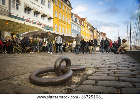 Copenhagen, Denmark - October 26, 2013: Nyhavn, The Danish Capital\'S Most Famous Street, Crowded As Usual, Its Lined Colorful Houses And Boat Masts On The Canal, Seen From An Unusual Perspective