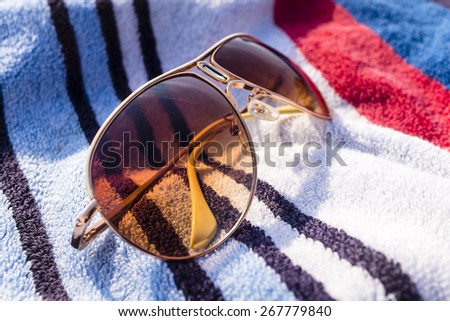 unbranded brown sun glasses on beach towel (shallow depth of field)