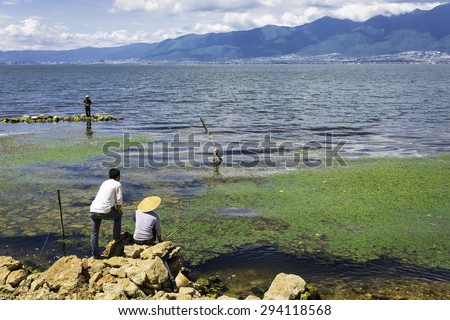 fishermen fishing with rod and line in the banks of Erhai lake (Dali, Yunnan, China)
