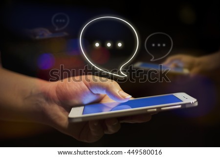 Close up of women\'s hand holding mobile phone at night with bokeh background, chatting,Chat bubble, Chat with friends,social nekwork,