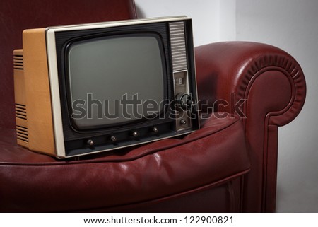 vintage tv on a red leather couch