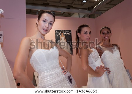 MILAN, ITALY - JUNE 21: Models with wedding dresses pose at SposaItalia, international exhibition of bridal and formal wear according to Italian style, on JUNE 21, 2013 in Milan