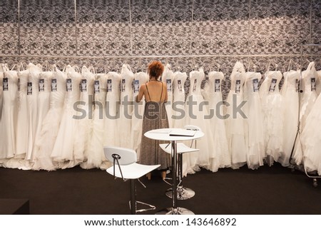 MILAN, ITALY - JUNE 21:  White wedding dresses hung up in a stand at SposaItalia, international exhibition of bridal and formal wear according to Italian style, on JUNE 21, 2013 in Milan