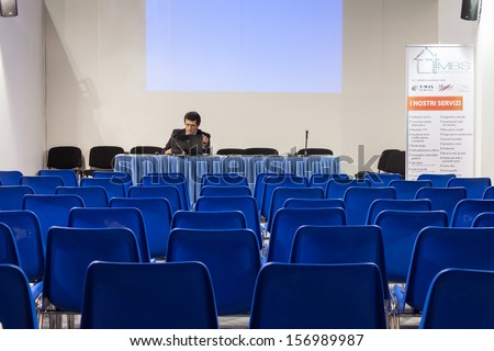 MILAN, ITALY - OCTOBER 3: A speaker prepares his lecture before people come at Made expo, international architecture and building trade show on OCTOBER 3, 2013 in Milan.