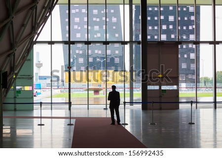 MILAN, ITALY - OCTOBER 3: A security man in silhouette at Made expo, international architecture and building trade show on OCTOBER 3, 2013 in Milan.