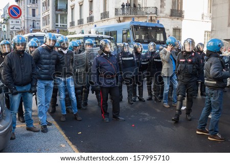MILAN, ITALY - OCTOBER 11: Riot police confronts secondary school students marching in the city streets to protest against money cuts in the public school on OCTOBER 11, 2013 in Milan.