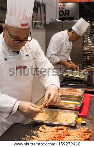 MILAN, ITALY - OCTOBER 18: A cook prepares red prawns at Host 2013, international exhibition of the hospitality industry on OCTOBER 18, 2013 in Milan.