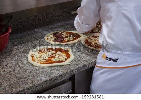 MILAN, ITALY - OCTOBER 18: Pizza preparation at Host 2013, international exhibition of the hospitality industry on OCTOBER 18, 2013 in Milan.