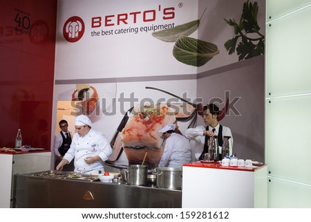 MILAN, ITALY - OCTOBER 18: A young chef prepares food at Host 2013, international exhibition of the hospitality industry on OCTOBER 18, 2013 in Milan.
