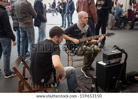 MILAN, ITALY - OCTOBER 20: Musicians play guitar at Milano Guitars & Beyond 2013, important trade show of string instruments with specific attention to guitars on OCTOBER 20, 2013 in Milan.