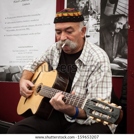 MILAN, ITALY - OCTOBER 20: A musician plays guitar at Milano Guitars & Beyond 2013, important trade show of string instruments with specific attention to guitars on OCTOBER 20, 2013 in Milan.