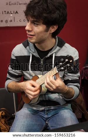 MILAN, ITALY - OCTOBER 20: Musician plays small guitar at Milano Guitars & Beyond 2013, important trade show of string instruments with specific attention to guitars on OCTOBER 20, 2013 in Milan.