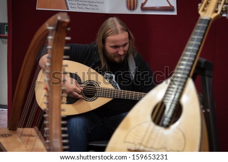 MILAN, ITALY - OCTOBER 20: A musician plays mandoloncello at Milano Guitars & Beyond 2013, important trade show of string instruments with specific attention to guitars on OCTOBER 20, 2013 in Milan.