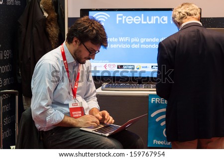 MILAN, ITALY - OCTOBER 23: A young man works on his netbook at Smau, international exhibition of information communications technology on OCTOBER 23, 2013 in Milan.
