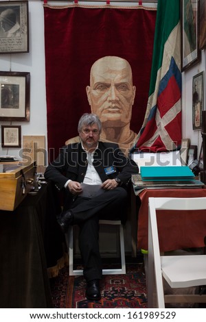 MILAN, ITALY - NOVEMBER 2: An exhibitor sits in his stand at Militalia, exhibition dedicated to militaria collectors and military associations on NOVEMBER 2, 2013 in Milan.