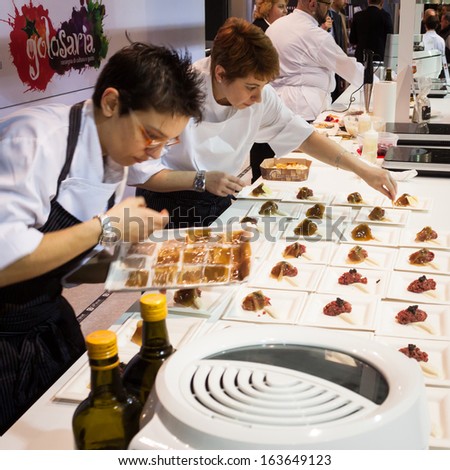 MILAN, ITALY - NOVEMBER 18: Chef\'s assistants work at Golosaria, important event dedicated to culture and tradition of quality food and wine on NOVEMBER 18, 2013 in Milan.