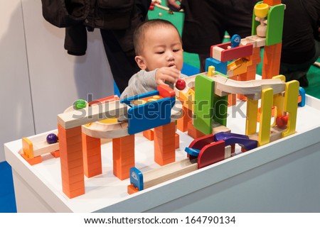 MILAN, ITALY - NOVEMBER 22: Little child plays at G! come giocare, trade fair dedicated to games, toys and children on NOVEMBER 22, 2013 in Milan.