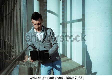 Handsome young man working at computer and listening to music outdoor