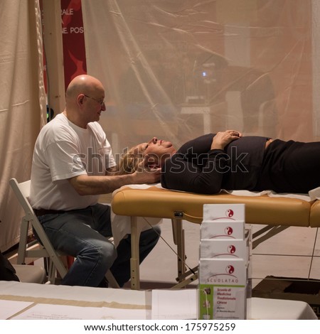 MILAN, ITALY - FEBRUARY 7: Professional masseur works at Olis Festival, event dedicated to holistic disciplines, alternative medicine and natural food on FEBRUARY 7, 2014 in Milan.